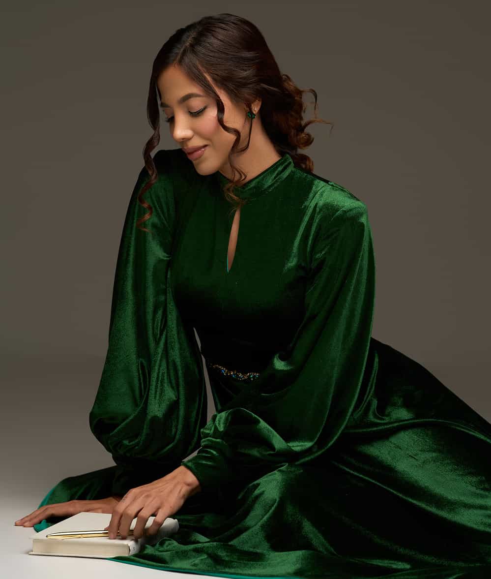 Coach María Daniela Velasco sentada en el piso, usando su libro como una guía para la introspección y el autodescubrimiento.