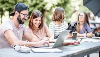 young-people-working-outdoor-cafe-young-people-sitting-big-table-working-studying-laptops-documents-121586417